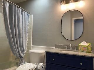 full bathroom with toilet, shower / tub combo, and vanity