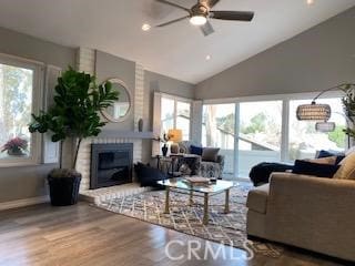 living room with vaulted ceiling, ceiling fan, a fireplace, and hardwood / wood-style flooring