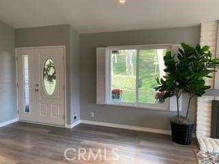 entryway featuring a brick fireplace and wood-type flooring