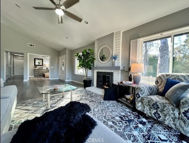 living room with hardwood / wood-style flooring, ceiling fan, lofted ceiling, and a fireplace