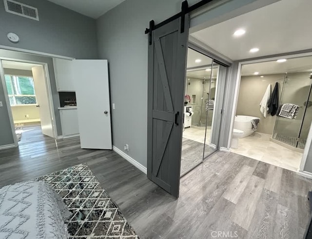 interior space with a tub to relax in and hardwood / wood-style flooring