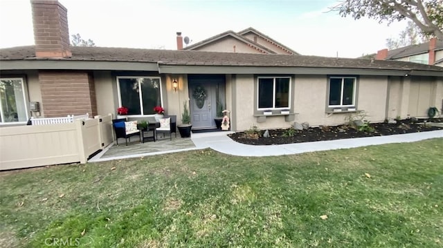 back of property with a yard and a patio