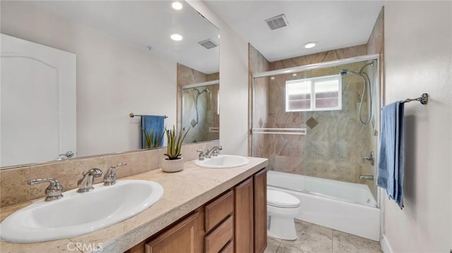 full bathroom featuring tile patterned flooring, vanity, toilet, and shower / bath combination with glass door