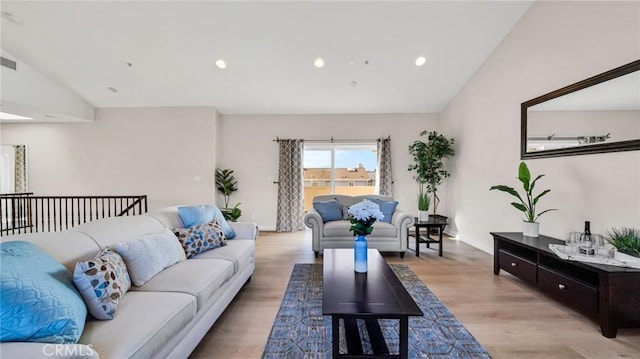 living room with light hardwood / wood-style floors and lofted ceiling