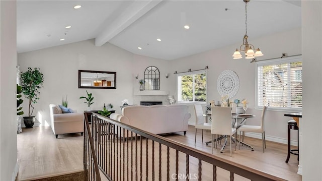 interior space with a chandelier, hardwood / wood-style floors, and lofted ceiling with beams