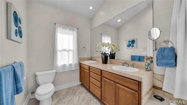 bathroom featuring vanity, toilet, and lofted ceiling