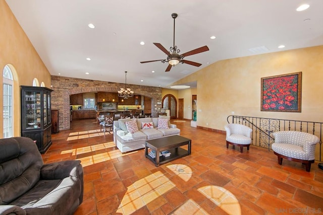 living room featuring ceiling fan with notable chandelier and high vaulted ceiling