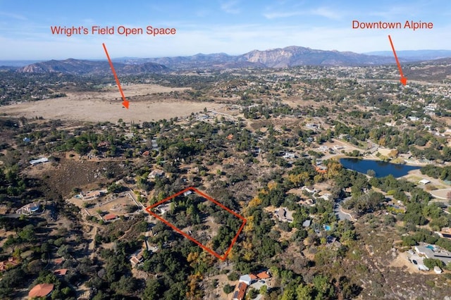 drone / aerial view featuring a water and mountain view