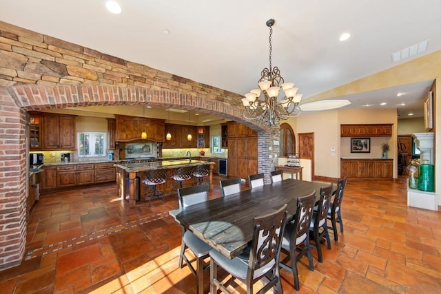 dining space featuring vaulted ceiling and an inviting chandelier