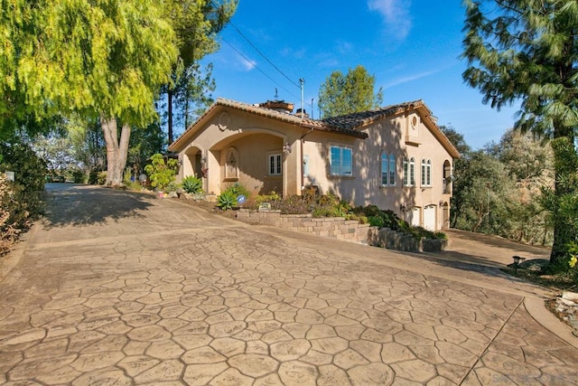 mediterranean / spanish-style home with a garage