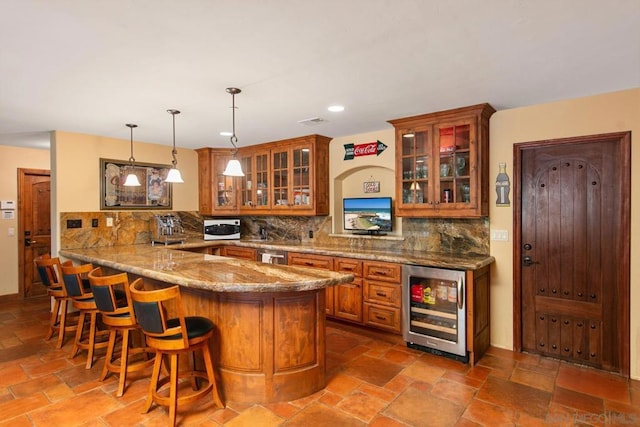 bar with pendant lighting, dishwasher, backsplash, wine cooler, and light stone counters