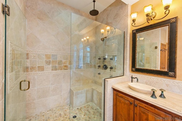 bathroom featuring a shower with door, vanity, and decorative backsplash