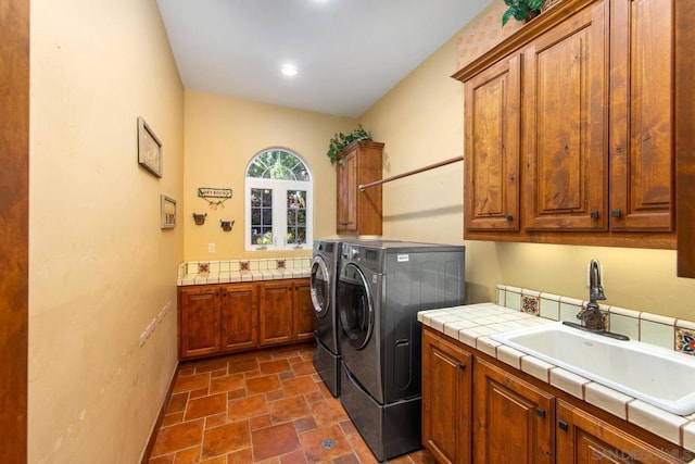 laundry area featuring cabinets, independent washer and dryer, and sink