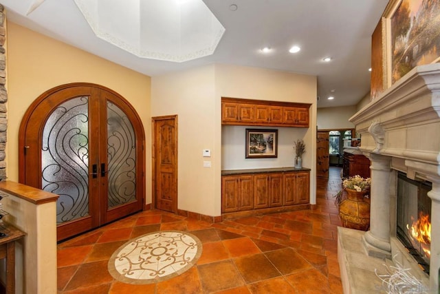 entrance foyer with french doors and a high end fireplace