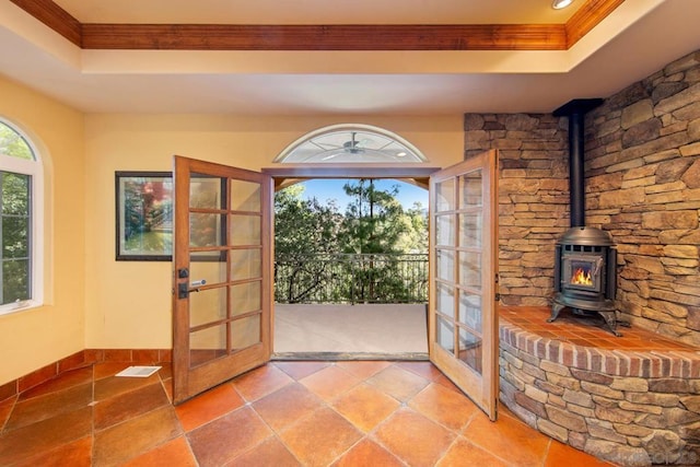 doorway featuring a tray ceiling, a wood stove, and french doors