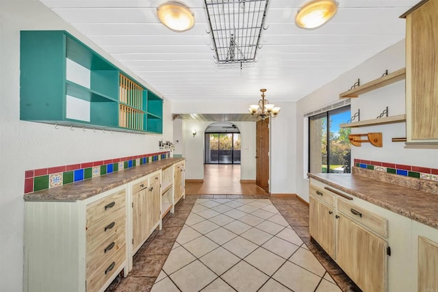 kitchen with pendant lighting, plenty of natural light, light tile patterned flooring, and an inviting chandelier