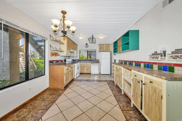 kitchen with an inviting chandelier, pendant lighting, light tile patterned floors, and white appliances