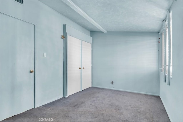 unfurnished bedroom with a textured ceiling and light carpet