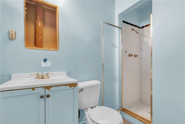 bathroom with a tile shower, vanity, and toilet