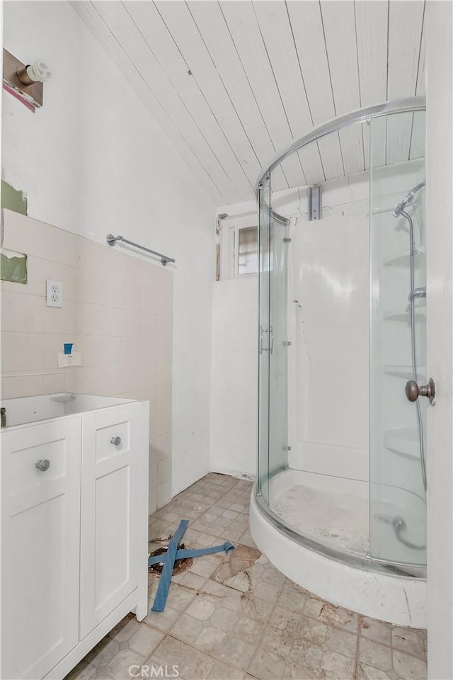 bathroom with vanity, lofted ceiling, a shower with door, tile patterned flooring, and wood ceiling