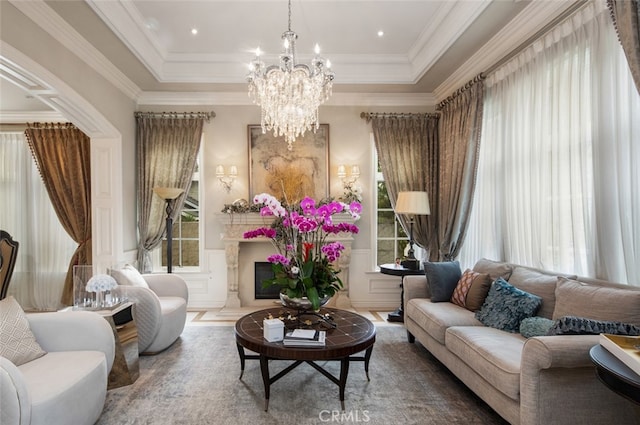 interior space with an inviting chandelier, a high end fireplace, and crown molding