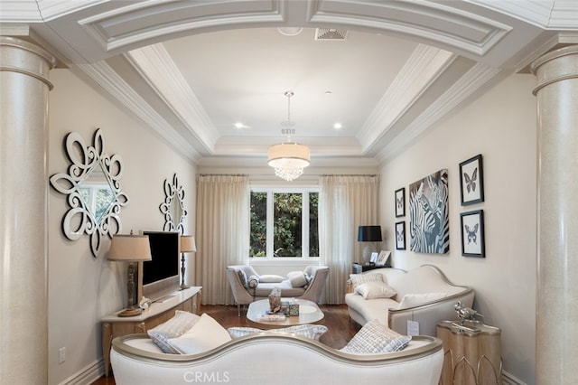 living room featuring hardwood / wood-style flooring, crown molding, and decorative columns