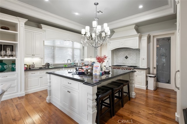 kitchen with white cabinets, decorative backsplash, dark wood-type flooring, and a kitchen island