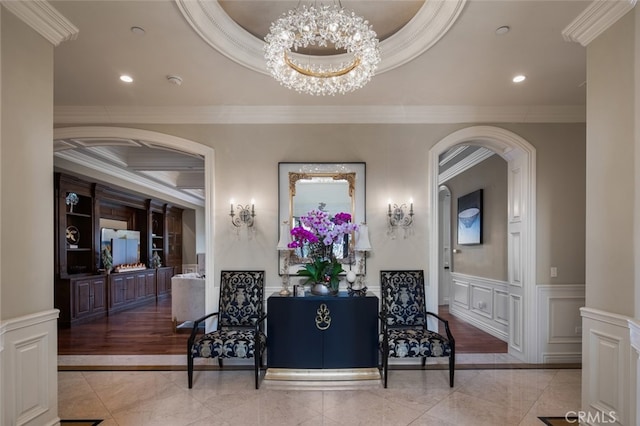 interior space with ornamental molding, a tray ceiling, and a notable chandelier