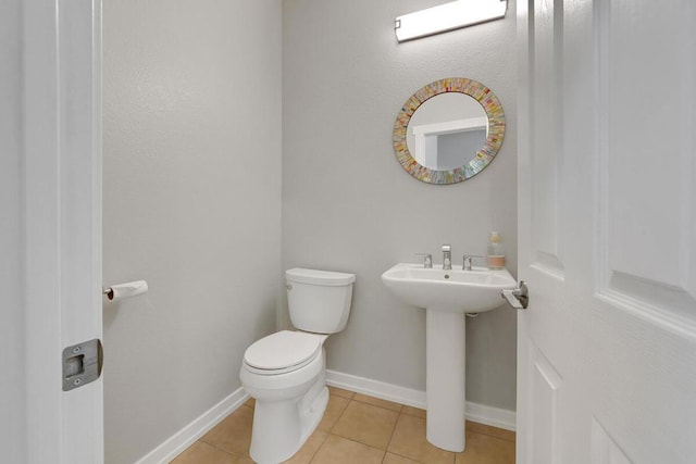 bathroom featuring toilet, tile patterned floors, and sink