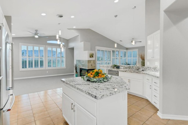 kitchen featuring white cabinets, ceiling fan, appliances with stainless steel finishes, decorative light fixtures, and a kitchen island