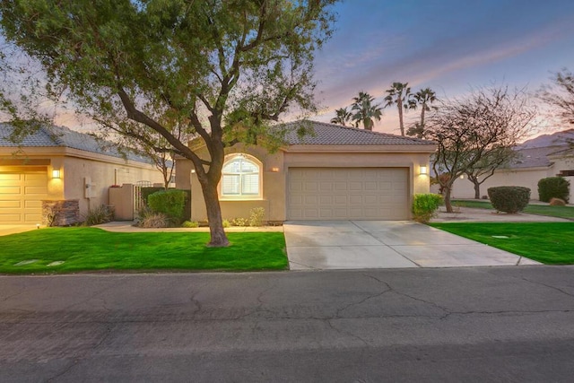 view of front of property with a garage and a yard