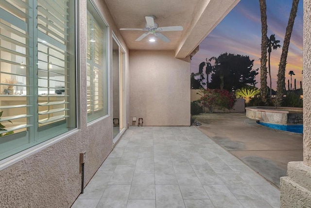 patio terrace at dusk featuring ceiling fan