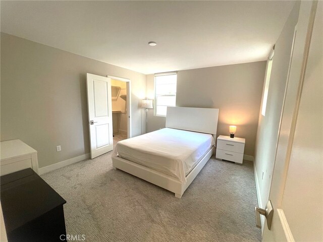 carpeted bedroom with a walk in closet