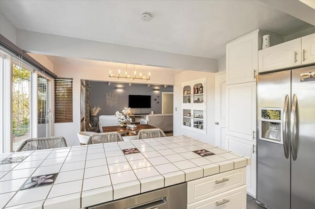 kitchen featuring tile counters, stainless steel fridge, built in features, and white cabinets