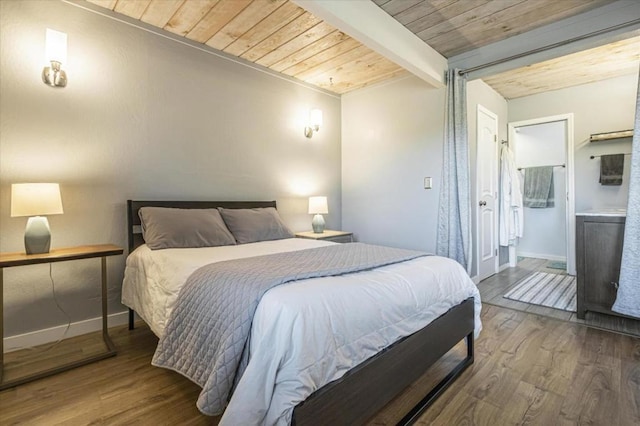 bedroom featuring beamed ceiling, connected bathroom, hardwood / wood-style floors, and wooden ceiling