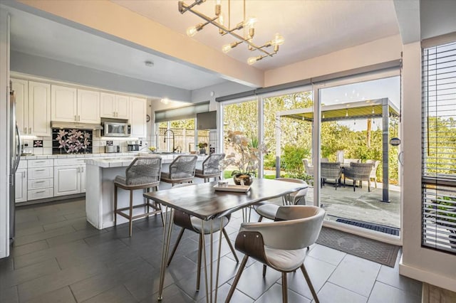 dining space with an inviting chandelier, sink, and beam ceiling