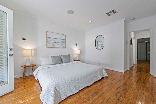 bedroom featuring light hardwood / wood-style flooring and crown molding