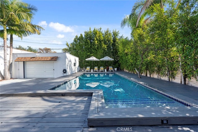 view of swimming pool with an outbuilding and a deck