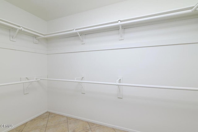 walk in closet featuring light tile patterned flooring