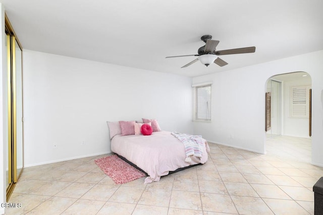 tiled bedroom featuring ceiling fan