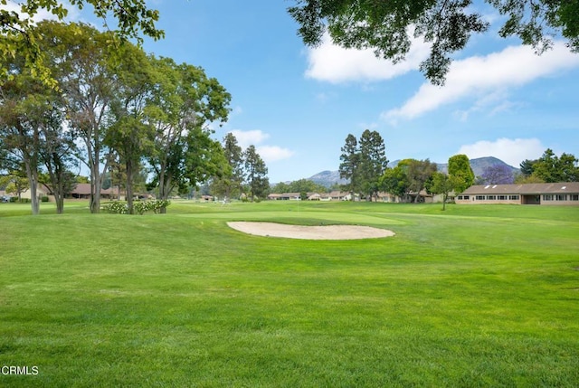 surrounding community with a mountain view and a yard