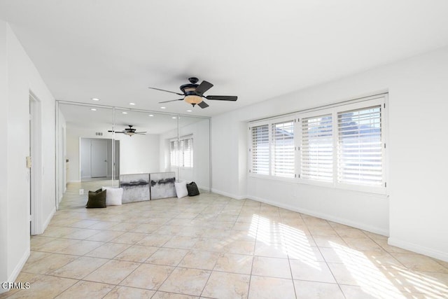 unfurnished living room with light tile patterned floors, plenty of natural light, and ceiling fan