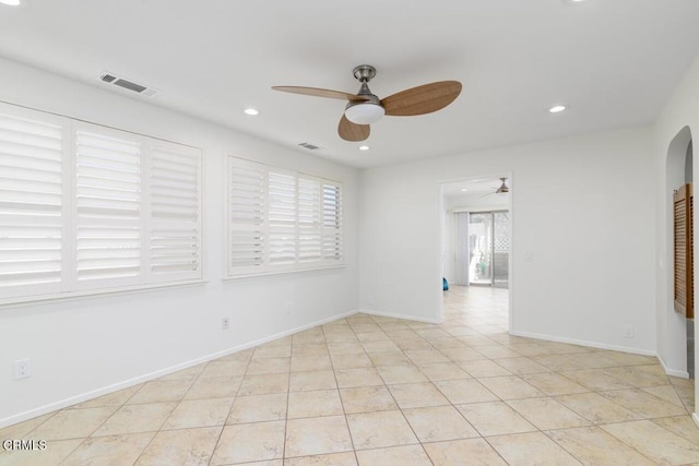 tiled empty room featuring ceiling fan