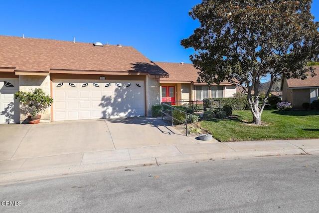 ranch-style home featuring a garage and a front lawn