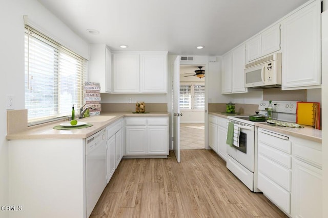 kitchen with white cabinets, light wood-type flooring, white appliances, and sink