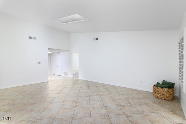 spare room with high vaulted ceiling and light tile patterned flooring