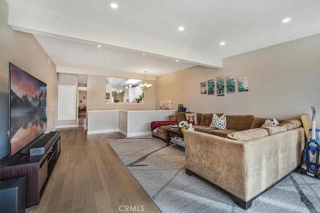 living room with a chandelier, beam ceiling, and wood-type flooring