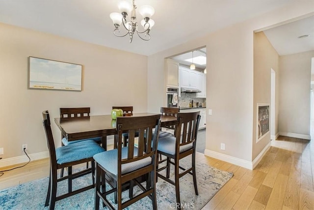 dining room with a chandelier and light hardwood / wood-style floors