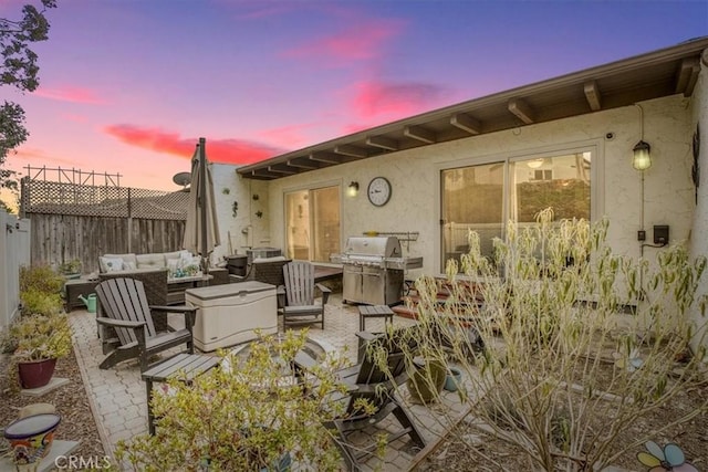 patio terrace at dusk featuring an outdoor living space and area for grilling