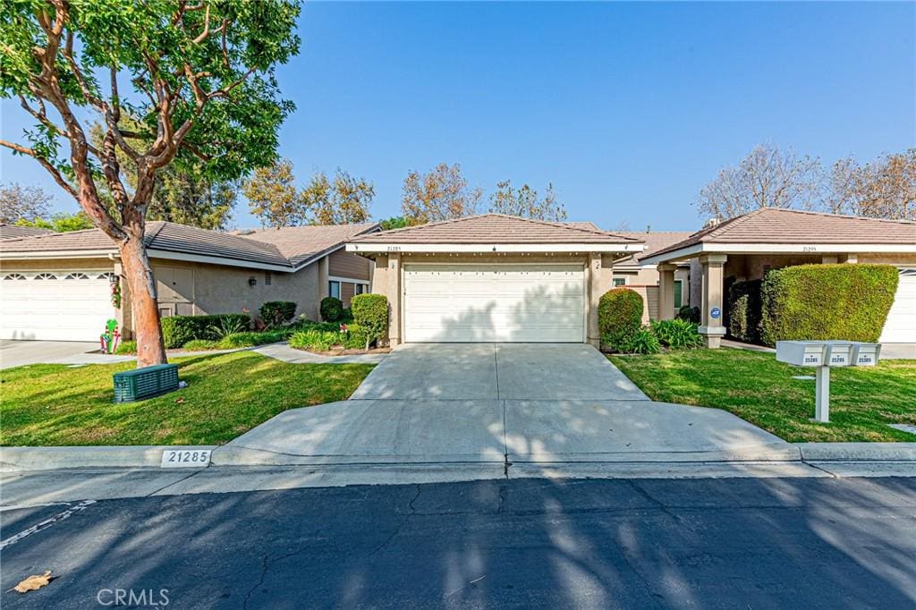 single story home with a garage and a front lawn